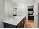 Spacious bathroom with double vanity, dark cabinets, a large mirror, and a view to the living room at 201 Mills Ln, Fort Mill, SC 29708
