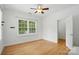 Bright bedroom with hardwood floors, ceiling fan, and a large window with plantation shutters at 201 Mills Ln, Fort Mill, SC 29708