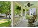Charming front porch featuring white railings, hanging plants, and comfortable rocking chairs at 201 Mills Ln, Fort Mill, SC 29708