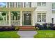 Inviting front porch with white columns, hanging ferns, and brick steps to the main entrance at 201 Mills Ln, Fort Mill, SC 29708
