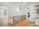 Bright upstairs hallway with hardwood floors and wood and metal railings leading to the staircase at 201 Mills Ln, Fort Mill, SC 29708