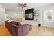 Open concept living room featuring a large sectional couch, built-in shelving, and abundant natural light at 201 Mills Ln, Fort Mill, SC 29708