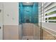 Modern shower featuring blue tiled walls, penny tile accents, and a frameless glass door for a sleek look at 201 Mills Ln, Fort Mill, SC 29708