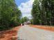 A new two-story home with a gravel driveway nestled among lush green trees at 2099 Cedar Rd, York, SC 29745