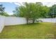 Large, grassy backyard enclosed by a white fence, offering plenty of space for outdoor activities at 210 Park St, Bessemer City, NC 28016