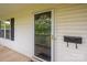 Exterior shot of the house featuring a storm door, mailbox, and window with black shutters at 210 Park St, Bessemer City, NC 28016