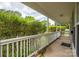 Long, covered front porch with white railing and a view of the lush greenery at 210 Park St, Bessemer City, NC 28016