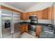 Well-lit kitchen featuring stainless steel appliances, wood cabinets, and a breakfast bar at 210 Park St, Bessemer City, NC 28016