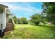 Spacious backyard featuring a large tree, green grass, and a small porch at 210 W 15Th St, Newton, NC 28658