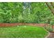 Backyard with green grass, lush trees, and a wooden fence at 2100 Sablewood Dr, Charlotte, NC 28205