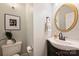 Stylish powder room with round mirror, pedestal sink and elegant fixtures at 2100 Sablewood Dr, Charlotte, NC 28205