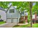 Charming two-story home with light blue siding, a two-car garage, and a beautifully landscaped front yard with mature trees at 2100 Sablewood Dr, Charlotte, NC 28205