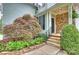 Inviting front porch with stone accents and manicured landscaping leading to the front door at 2100 Sablewood Dr, Charlotte, NC 28205
