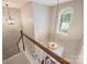 Staircase with carpeted steps and natural wood railing, illuminated by stylish light fixtures at 2100 Sablewood Dr, Charlotte, NC 28205