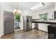 Well-lit kitchen featuring white cabinets, stainless steel appliances, dark countertops, and hardwood floors at 2109 Brewton Dr, Charlotte, NC 28206