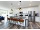 Modern kitchen features a large island with granite countertops, stainless appliances, and barstool seating at 2141 Bexar Trl, Matthews, NC 28105