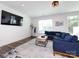 Cozy living room featuring a plush blue sofa, area rug, and ample natural light at 2141 Bexar Trl, Matthews, NC 28105