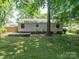 Backyard with a wood deck, providing a private retreat surrounded by mature trees and lush greenery at 21614 Colina Dr, Cornelius, NC 28031