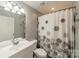 Bathroom with a patterned shower curtain and a white vanity at 21614 Colina Dr, Cornelius, NC 28031