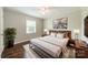 Cozy bedroom featuring wood floors, neutral walls, ceiling fan, and a modern platform bed at 21614 Colina Dr, Cornelius, NC 28031