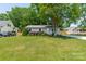 Charming single-story home with a lush green lawn, mature landscaping, and a quaint front porch at 21614 Colina Dr, Cornelius, NC 28031