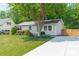Charming single-story home with a lush green lawn, mature landscaping, and a quaint front porch at 21614 Colina Dr, Cornelius, NC 28031