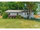 Charming single-story home with a lush green lawn, mature landscaping, and a quaint front porch at 21614 Colina Dr, Cornelius, NC 28031