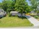 Well-kept lawn with mature trees and long driveway leading to a charming single-story home at 21614 Colina Dr, Cornelius, NC 28031