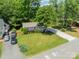 Aerial view of home featuring a long driveway, lush lawn, and mature trees providing ample shade at 21614 Colina Dr, Cornelius, NC 28031