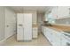 Well-lit kitchen featuring white cabinetry, tile floors, and modern appliances at 21614 Colina Dr, Cornelius, NC 28031