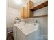 Functional laundry room with washer, dryer, utility sink, and storage shelves at 21614 Colina Dr, Cornelius, NC 28031