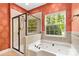 Bathroom with a tub, glass shower, window, and attractive wallpaper to create a unique focal point at 2346 Donnington Nw Ln, Concord, NC 28027