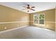 A bright, carpeted bedroom with a ceiling fan and a large window at 2346 Donnington Nw Ln, Concord, NC 28027