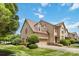 Side view of the brick home highlighting the well-kept lawn, mature landscaping, and an attached two-car garage at 2346 Donnington Nw Ln, Concord, NC 28027