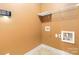Functional laundry room with utility connections, overhead shelving for storage and modern lighting at 2346 Donnington Nw Ln, Concord, NC 28027