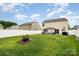 The spacious backyard features a fire pit and a pergola with seating, enclosed by a pristine white fence at 2423 Dewey Creek Ln, Charlotte, NC 28216