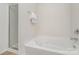 White bathtub and shower combo in a modern bathroom with tiled floors at 2423 Dewey Creek Ln, Charlotte, NC 28216