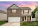 Beautiful two-story home with a brick and vinyl exterior, boasting a well-manicured lawn and inviting facade at 2423 Dewey Creek Ln, Charlotte, NC 28216