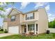 Inviting two-story home with a charming front porch, well-manicured lawn, and attached two car garage at 2423 Dewey Creek Ln, Charlotte, NC 28216
