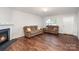 Cozy living room featuring a fireplace, wood floors, and comfortable seating at 2423 Dewey Creek Ln, Charlotte, NC 28216
