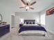 Comfortable bedroom featuring a large bed, ceiling fan, windows, and light gray walls at 2608 Henry Baucom Rd, Monroe, NC 28110