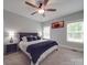 Comfortable bedroom featuring a large bed, ceiling fan, windows, and light gray walls at 2608 Henry Baucom Rd, Monroe, NC 28110
