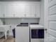 Bright laundry room featuring white cabinetry, Whirlpool appliances, sink, and light gray walls at 2608 Henry Baucom Rd, Monroe, NC 28110