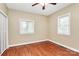 A bedroom featuring wood floors, neutral walls, two windows with blinds, and a ceiling fan at 261 Melrose Sw Dr, Concord, NC 28025