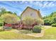 Lush backyard with a house featuring a wooden deck, surrounded by green trees at 261 Melrose Sw Dr, Concord, NC 28025