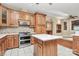 Bright eat-in kitchen features custom wood cabinets, stainless steel appliances, mosaic backsplash, and center island at 261 Melrose Sw Dr, Concord, NC 28025