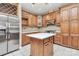 Well-lit kitchen features custom wood cabinets, stainless steel appliances, kitchen island and mosaic tile backsplash at 261 Melrose Sw Dr, Concord, NC 28025