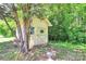Charming outdoor shed nestled among trees with white walls and unique cross-design door detail at 261 Melrose Sw Dr, Concord, NC 28025