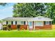 Charming single-story home with a brick facade, mature trees, and a well-maintained lawn at 2823 Albany Ln, Charlotte, NC 28205