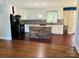 Bright kitchen featuring white cabinets, black appliances, a central island, and hardwood floors at 2823 Albany Ln, Charlotte, NC 28205